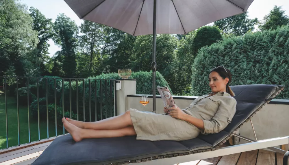 Frau liegt auf Liegestuhl auf der Terrasse